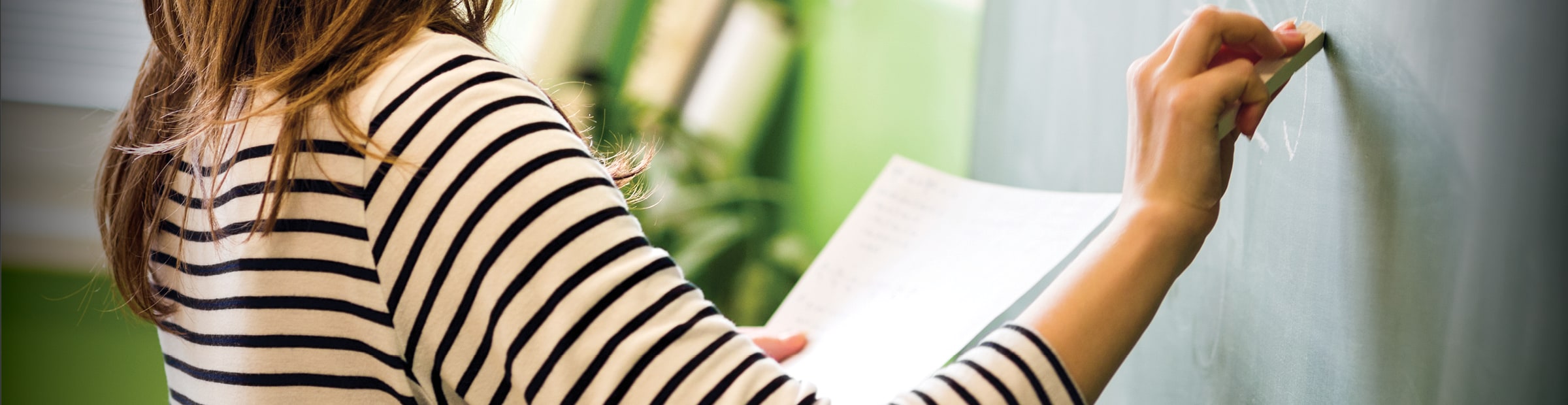 woman writing on a chalkboard